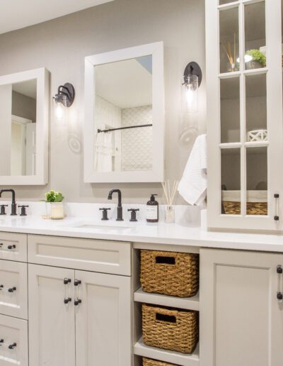 A bathroom with white cabinets and wicker baskets.