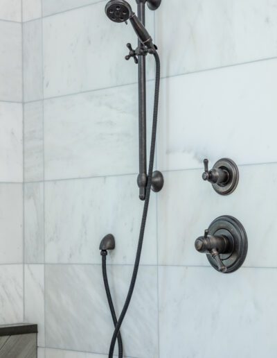 A bathroom with a shower head and hand shower.