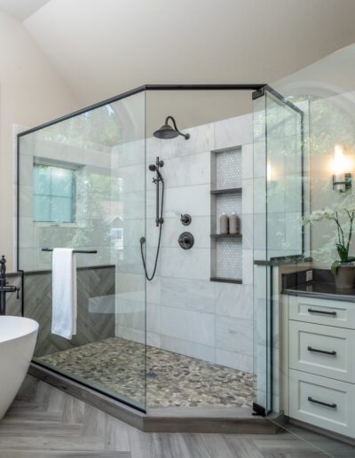 A large bathroom with a glass shower stall.