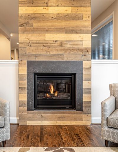 A living room with a fireplace and chairs.