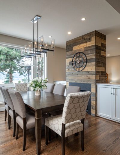 A dining room with hardwood floors and a fireplace.