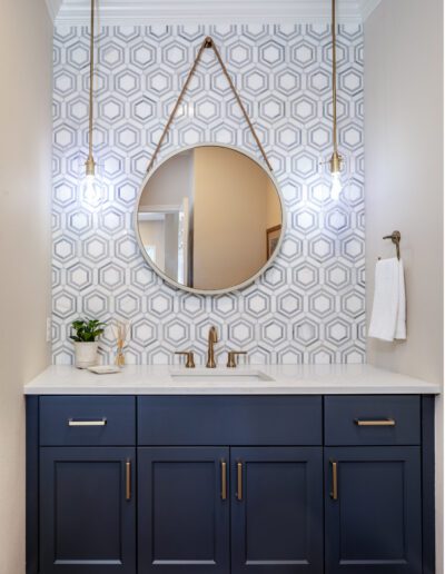 A bathroom with a blue vanity and mirror.