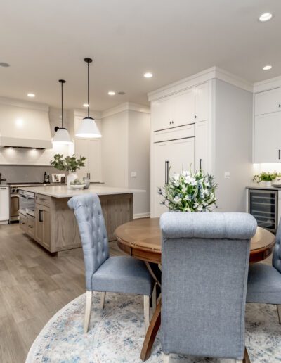 A white kitchen with a dining table and chairs.