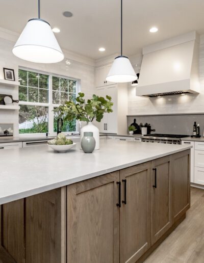 A white kitchen with wood floors and a center island.