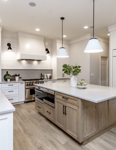 A white kitchen with wood floors and a center island.