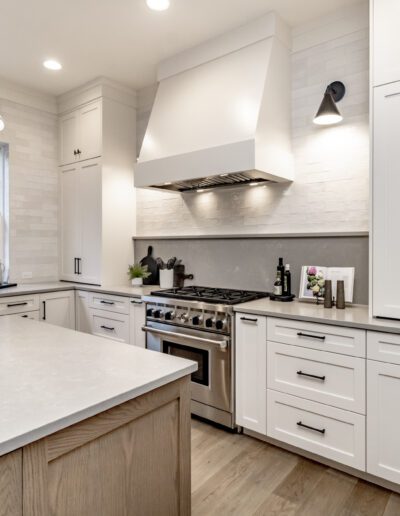 A modern kitchen with white cabinets and stainless steel appliances.