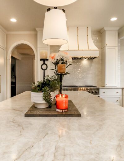 A white kitchen with a marble counter top.