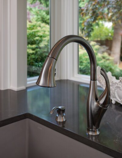 A kitchen sink with a faucet and a window.