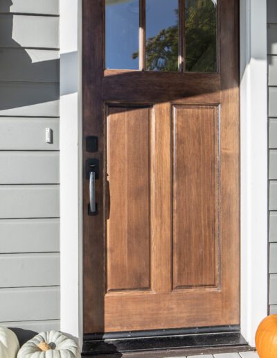 A wooden front door with pumpkins on it.