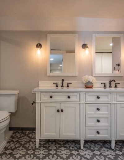 A white bathroom with a black and white tile floor.