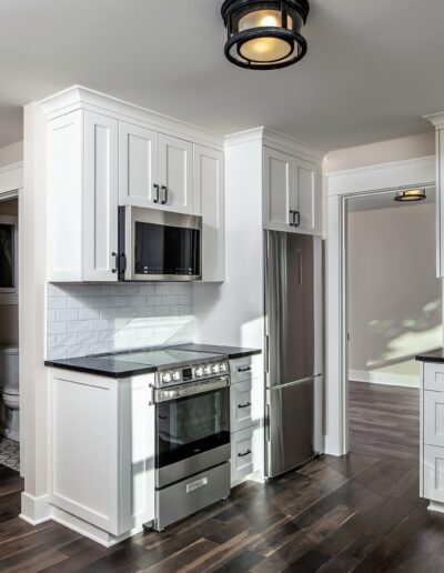 A kitchen with white cabinets and stainless steel appliances.