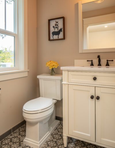 A bathroom with a toilet, sink and window.