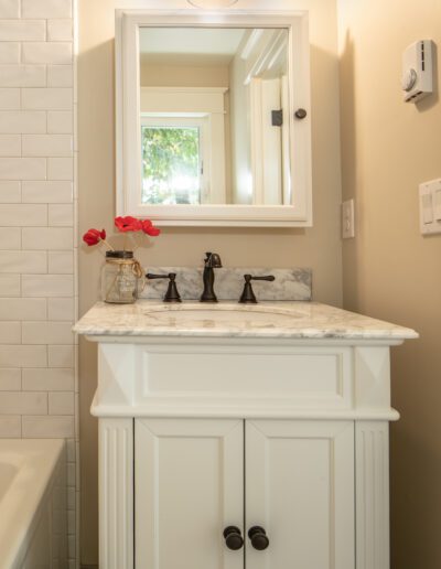 A white bathroom with a sink and mirror.