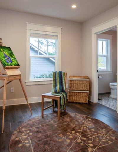 A room with a painting easel and a rug.