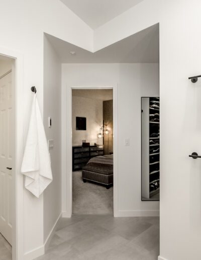 A white bathroom with a towel rack and mirror.