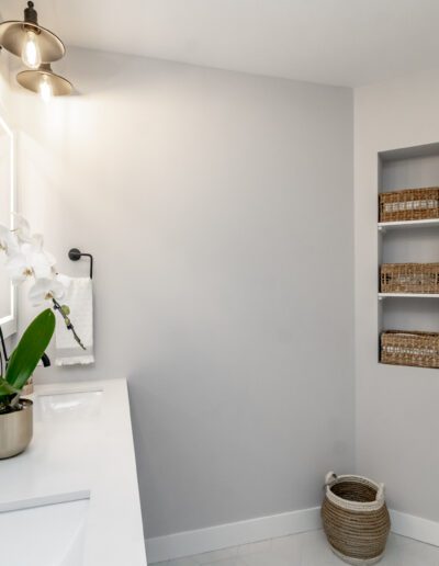 A white bathroom with a white sink and mirror.