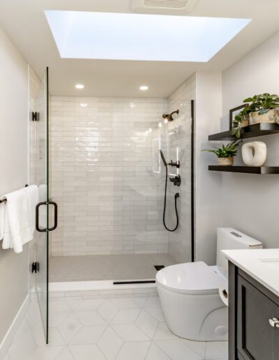 A white and gray bathroom with a skylight.