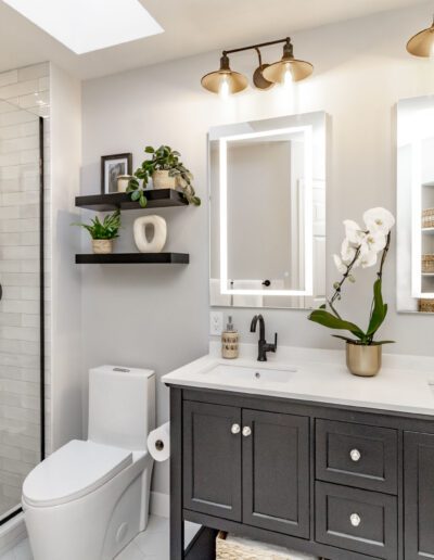 A black and white bathroom with a glass shower.