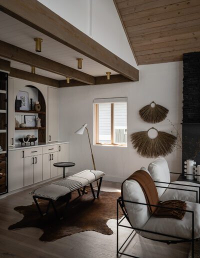 A living room with wood beams and a cowhide rug.