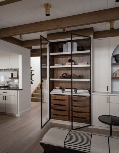 A white kitchen with wooden cabinets and a wooden floor.