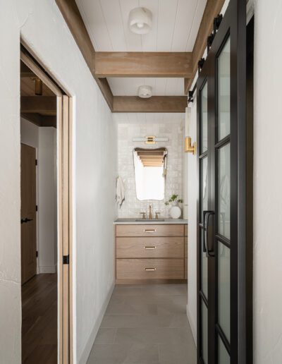 A bathroom with a wooden floor and a glass door.