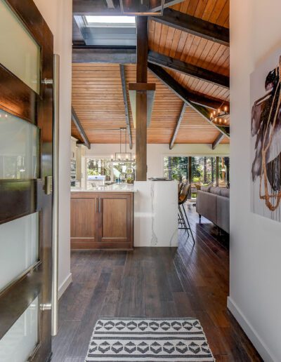 A hallway with a wooden door and a rug.