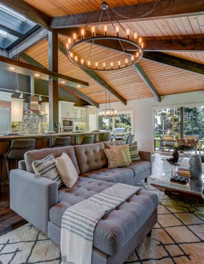 A living room with wood ceilings and a fireplace.