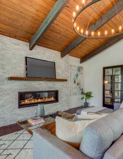 A living room with wood beams and a fireplace.