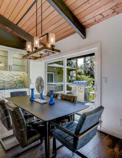 A kitchen with wood ceilings and a dining table.