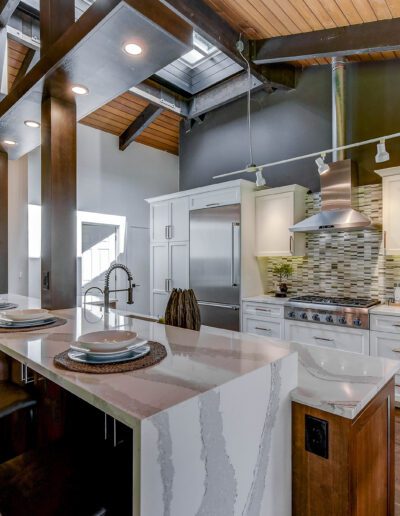 A kitchen with wood beams and a center island.