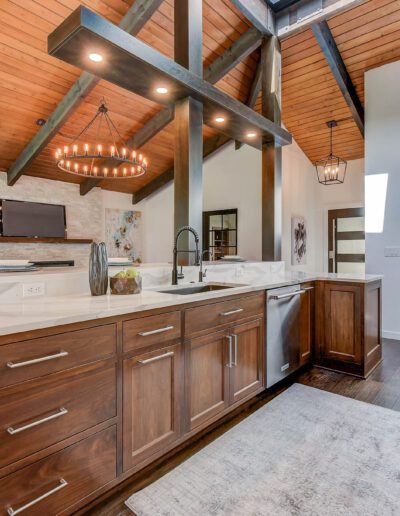 A modern kitchen with wood cabinets and a vaulted ceiling.