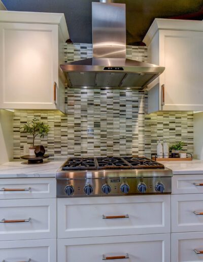 A kitchen with stainless steel appliances and white cabinets.