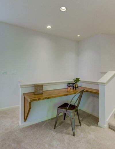 A room with a staircase and a desk.